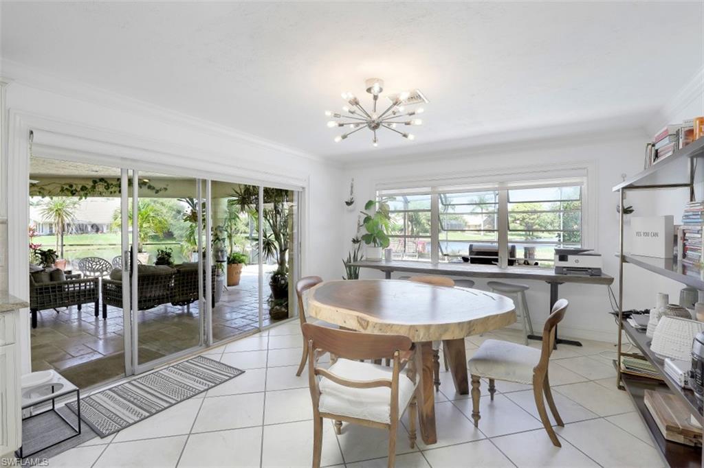 619 Neapolitan Way Naples, FL 34103 - Photo 17 of 32 a dining room with furniture a chandelier and wooden floor