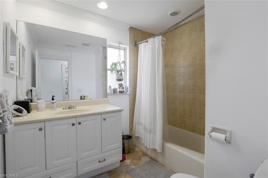 619 Neapolitan Way Naples, FL 34103 - Photo 20 of 32 a bathroom with a double vanity sink and mirror with shower