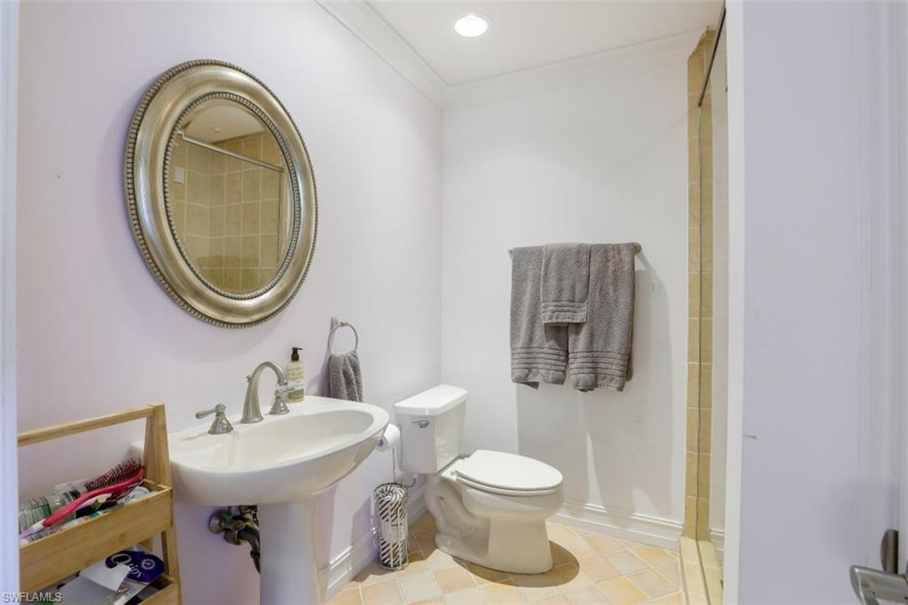 619 Neapolitan Way Naples, FL 34103 - Photo 22 of 32 a bathroom with a toilet a sink and a mirror
