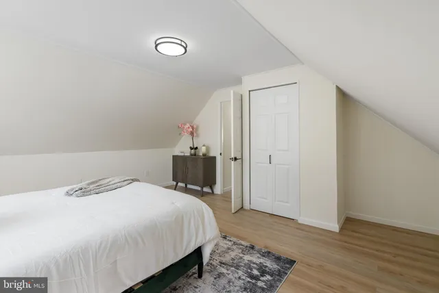 a bedroom with a bed and wooden floor