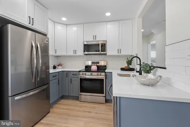a kitchen with sink a refrigerator and cabinets