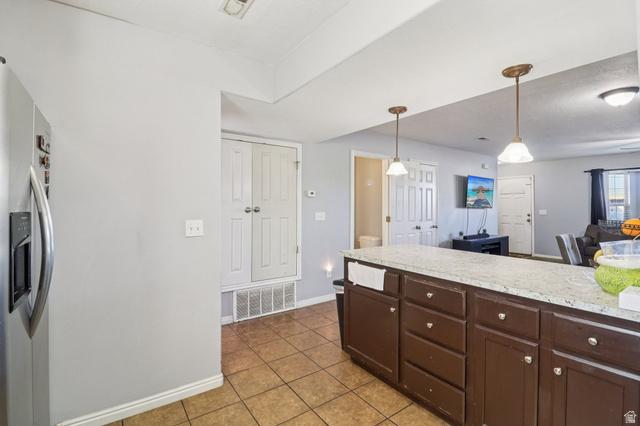 1077 South 1850th Street West Springville, UT 84663 - Photo 10 of 22 Kitchen featuring light countertops, pendant lighting, stainless steel refrigerator with ice dispenser, light tile patterned floors, and dark wood finish cabinetry