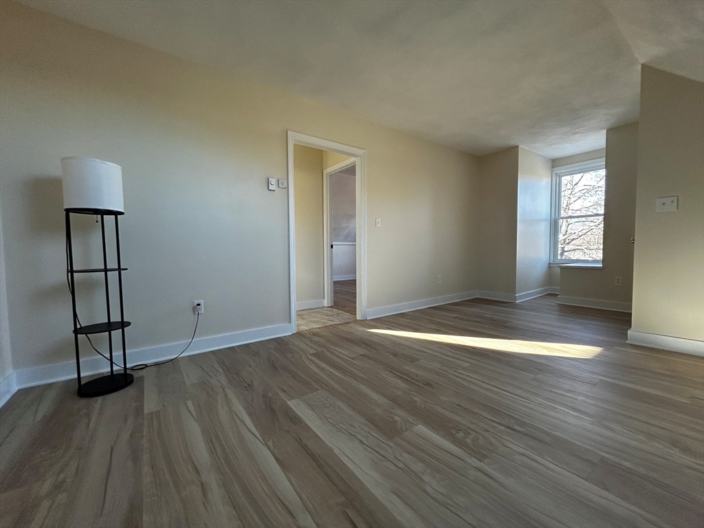 53 Hale Street, Unit 3 Beverly, MA 01915 - Photo 11 of 14 an empty room with wooden floor and windows
