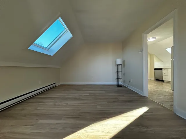 a view of empty room with wooden floor