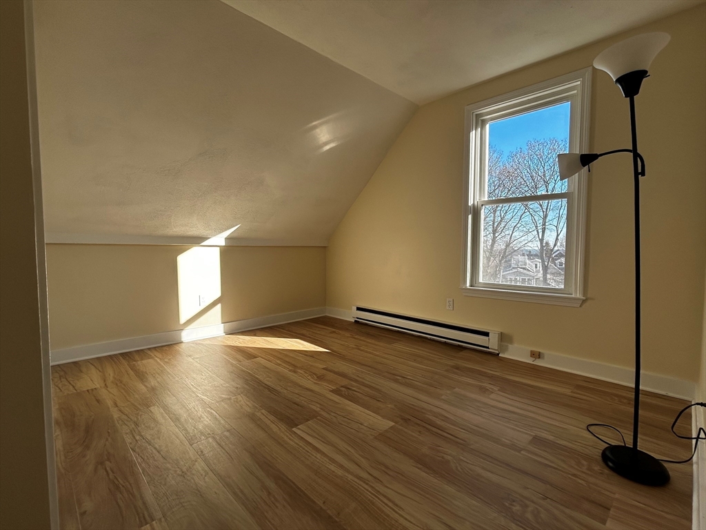 53 Hale Street, Unit 3 Beverly, MA 01915 - Photo 13 of 14 a view of an empty room with wooden floor and a window