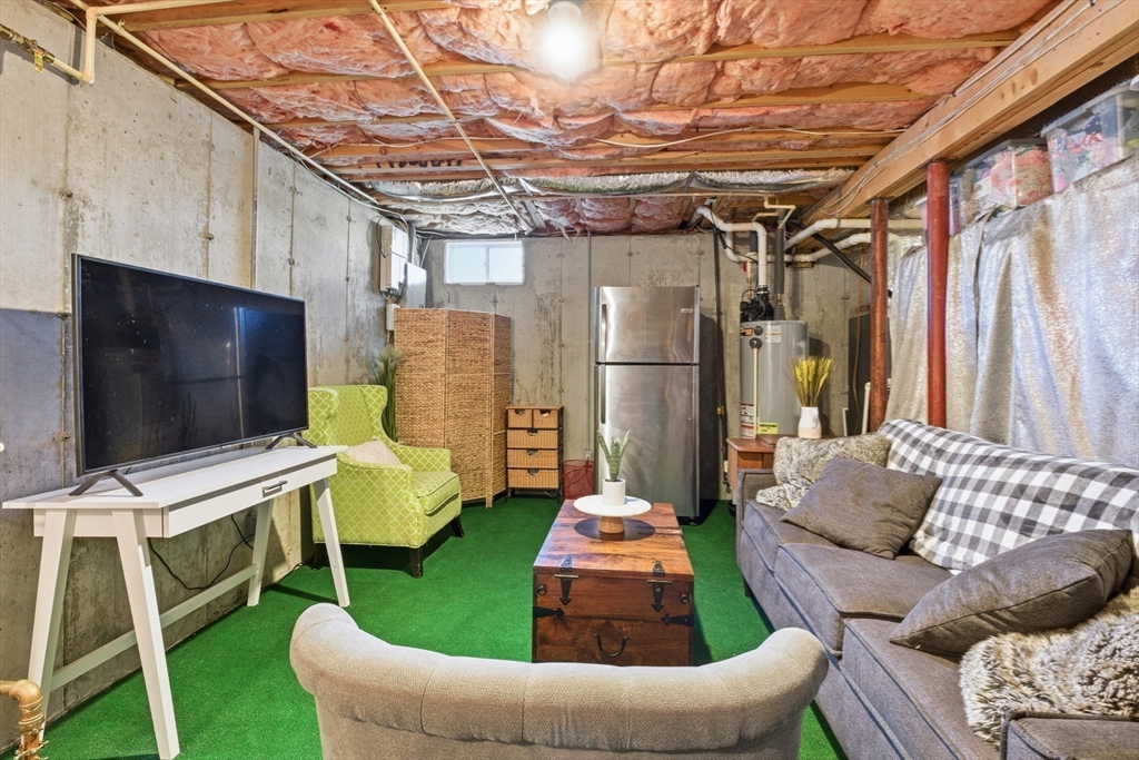 27 Emerson Street, Unit 27 Stoneham, MA 02180 - Photo 21 of 29 a living room with furniture and a flat screen tv