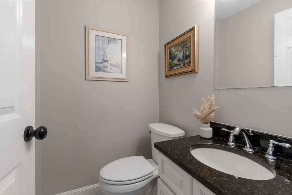 27 Emerson Street, Unit 27 Stoneham, MA 02180 - Photo 6 of 29 a bathroom with a granite countertop toilet sink and mirror