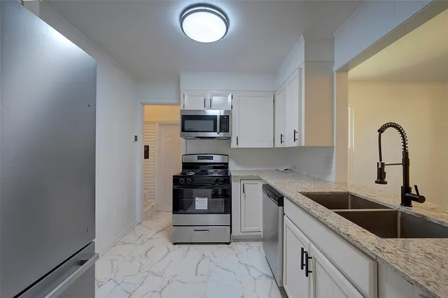 a kitchen with a sink cabinets and stainless steel appliances