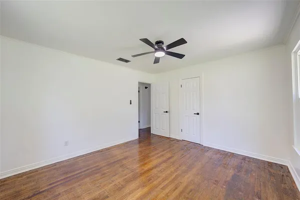 a view of a big room with wooden floor and a ceiling fan