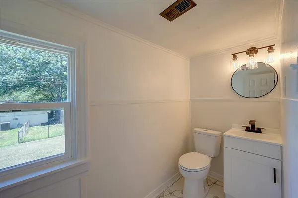 a bathroom with a toilet sink and window