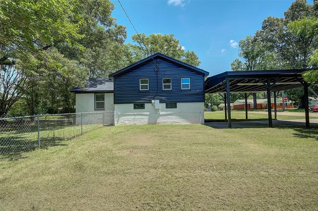 a view of house with backyard and trees