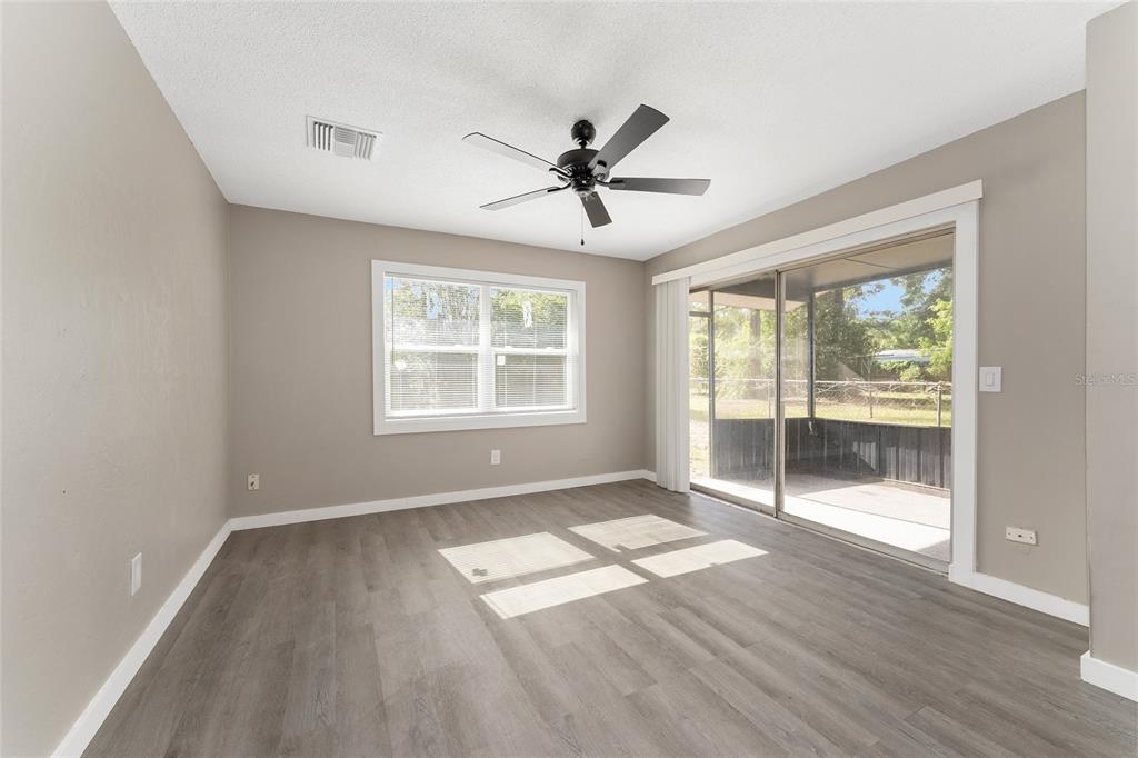 919 Southeast 19th Street Gainesville, FL 32641 - Photo 11 of 50 an empty room with wooden floor fan and windows