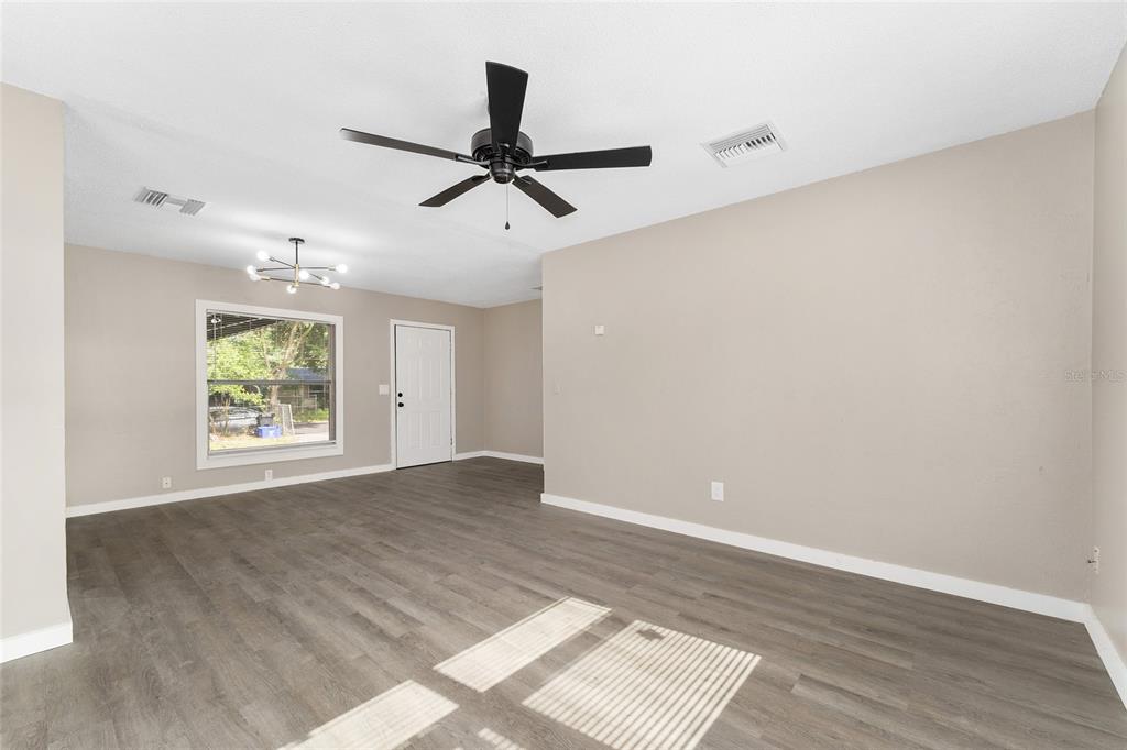 919 Southeast 19th Street Gainesville, FL 32641 - Photo 13 of 50 an empty room with wooden floor fan and windows