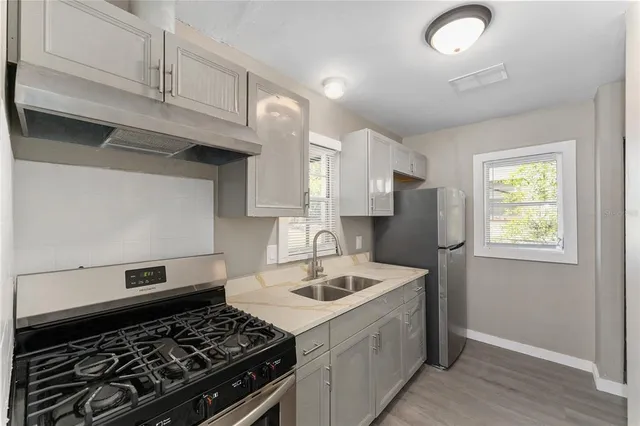 a kitchen with a stove a sink and a refrigerator