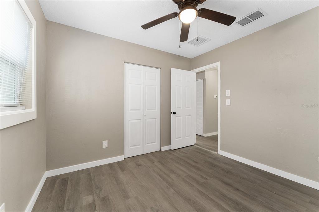 919 Southeast 19th Street Gainesville, FL 32641 - Photo 22 of 50 an empty room with wooden floor and windows