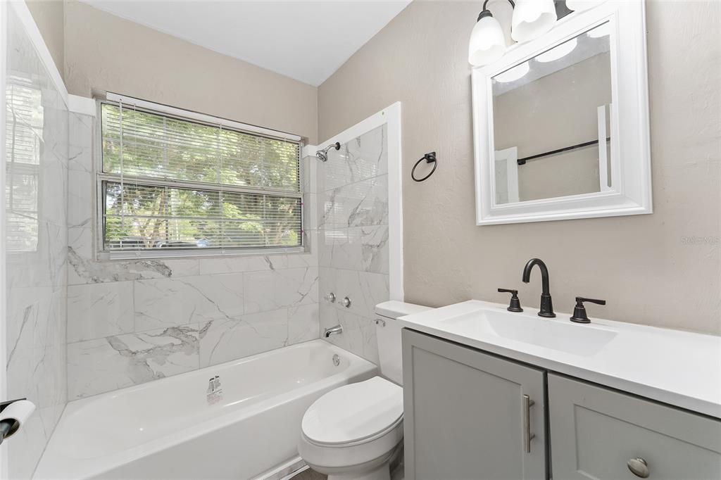 919 Southeast 19th Street Gainesville, FL 32641 - Photo 23 of 50 a bathroom with a sink a toilet and shower