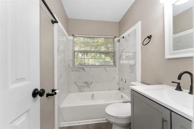 a bathroom with a bathtub shower sink vanity and toilet