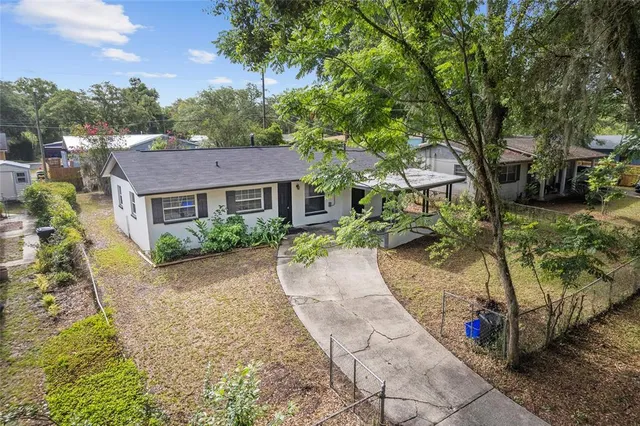 a aerial view of a house with a yard and large trees