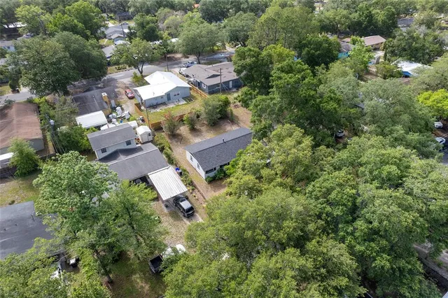 an aerial view of residential house with outdoor space and trees all around