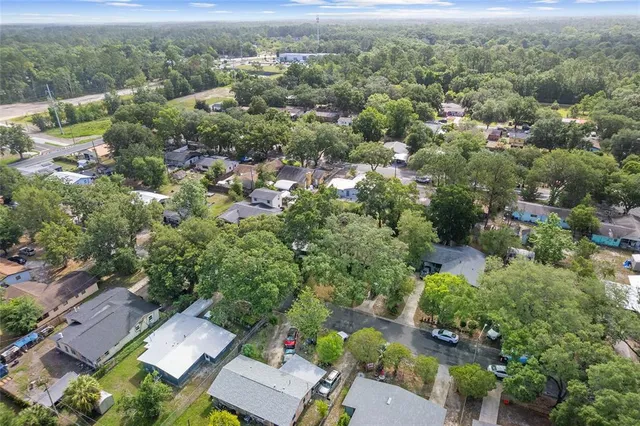 an aerial view of residential house with outdoor space and trees