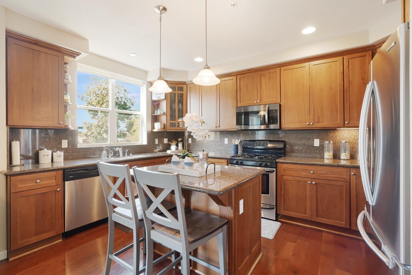 109 Esfahan Drive San Jose, CA 95111 - Photo 19 of 44 a kitchen with stainless steel appliances granite countertop a stove top oven a refrigerator a sink dishwasher a dining table and chairs with wooden floor