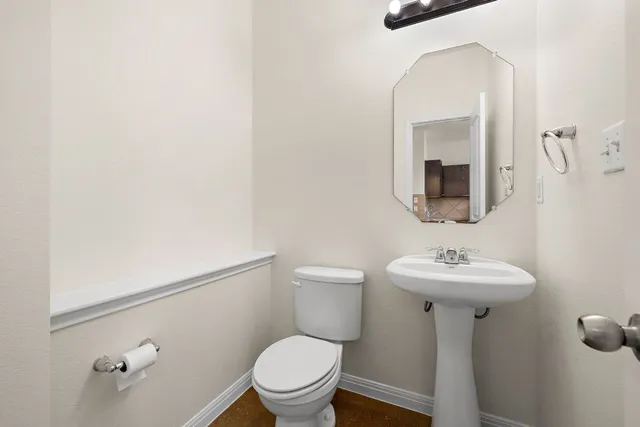 a bathroom with a toilet sink and mirror