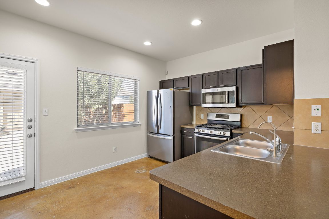 4602 Kind Way, Unit 287 Austin, TX 78725 - Photo 7 of 25 a kitchen with a refrigerator stove and sink