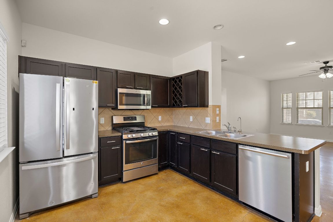 4602 Kind Way, Unit 287 Austin, TX 78725 - Photo 8 of 25 a kitchen with stainless steel appliances granite countertop a refrigerator a sink a stove a microwave and a refrigerator
