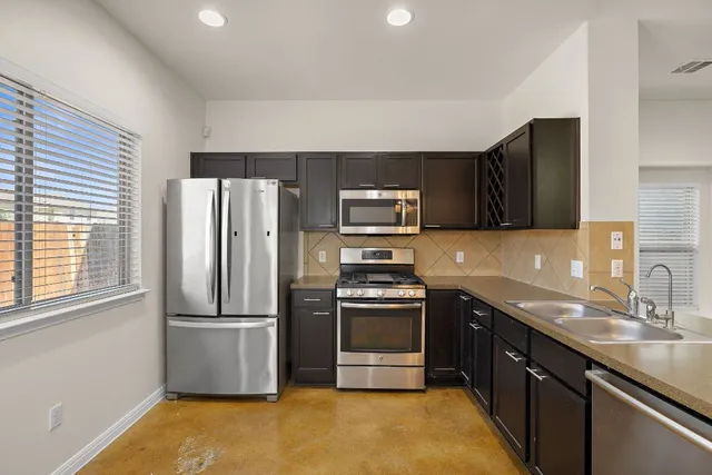 a kitchen with stainless steel appliances granite countertop a sink stove and refrigerator