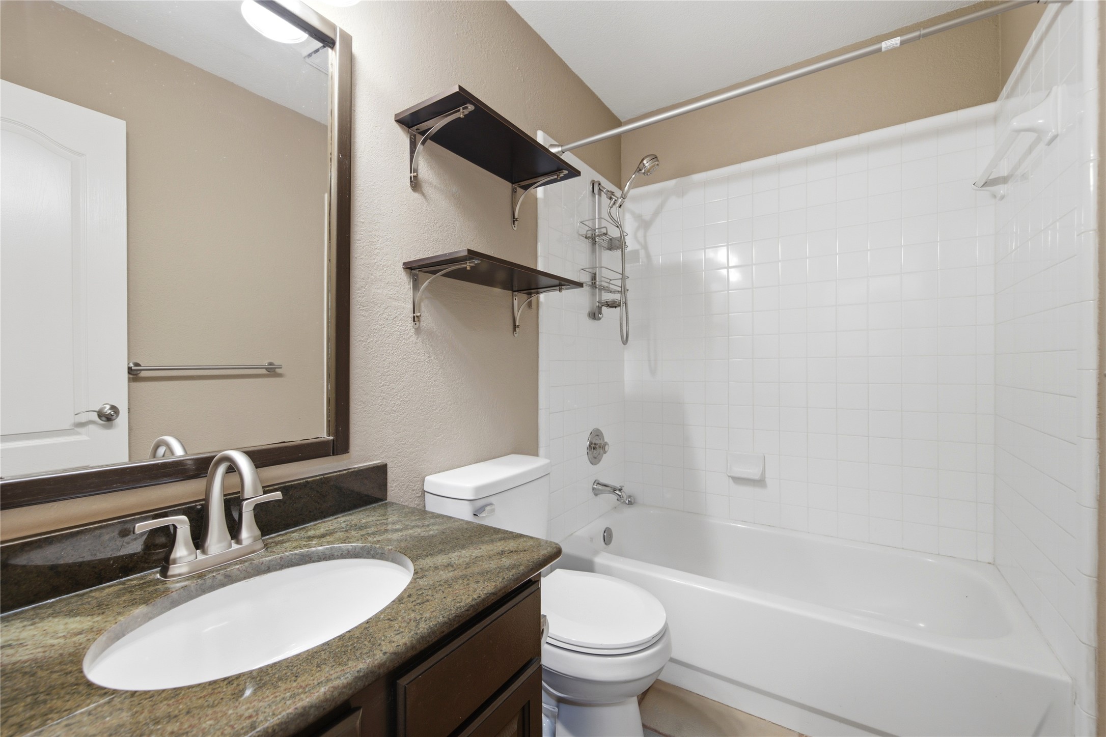 6032 Roxbury Lane Austin, TX 78739 - Photo 21 of 34 A classic tile surround tub completes this bathroom vanity setup.