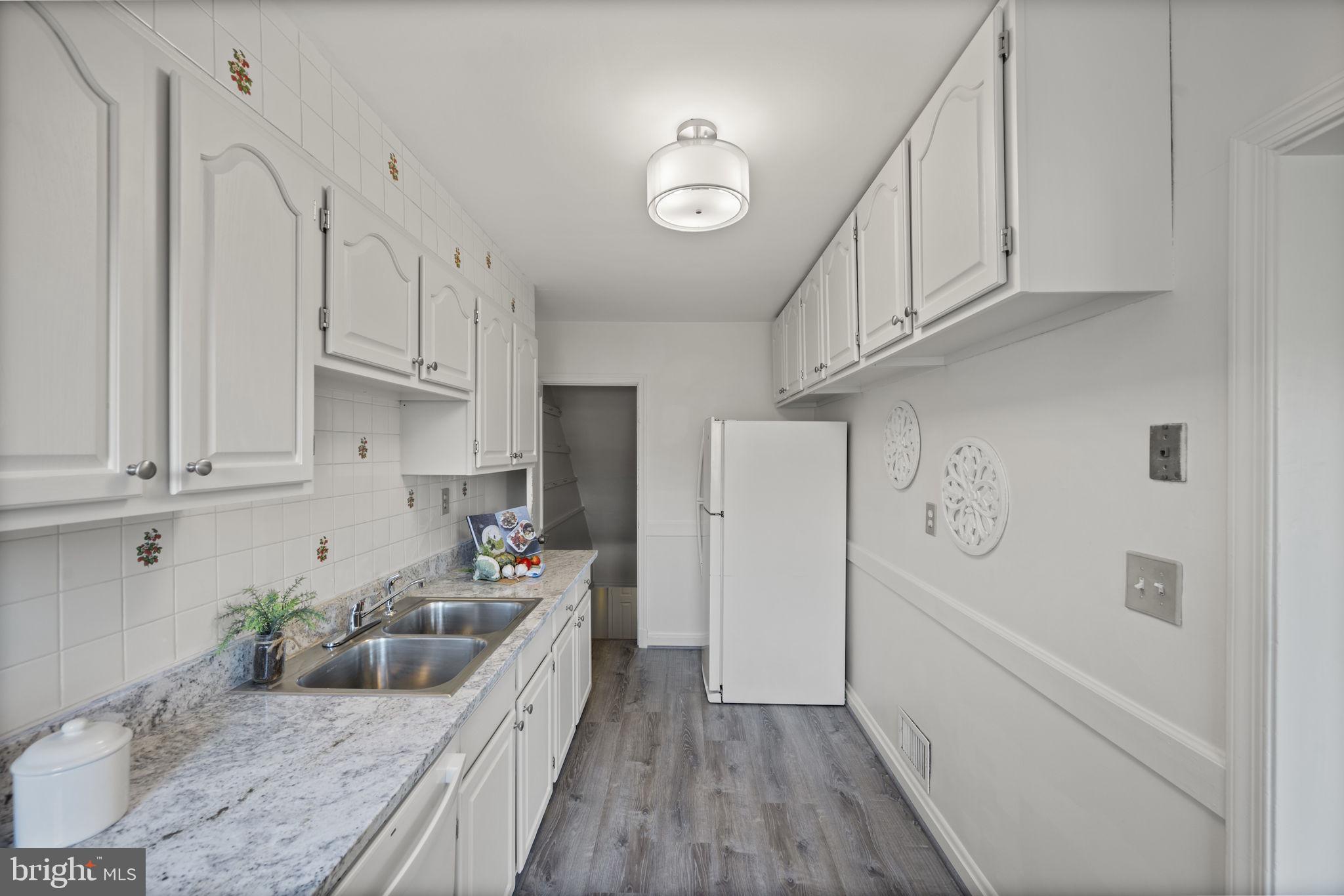 36 Darrow Drive Baltimore, MD 21228 - Photo 14 of 42 a kitchen with granite countertop a refrigerator a sink and white cabinets