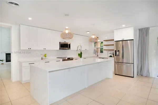 a kitchen with white cabinets and white appliances