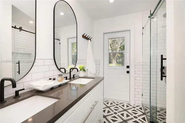 a en suite bathroom with a double vanity sink a mirror and a shower