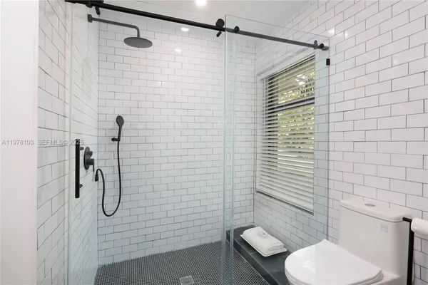 a bathroom with a toilet and a shower