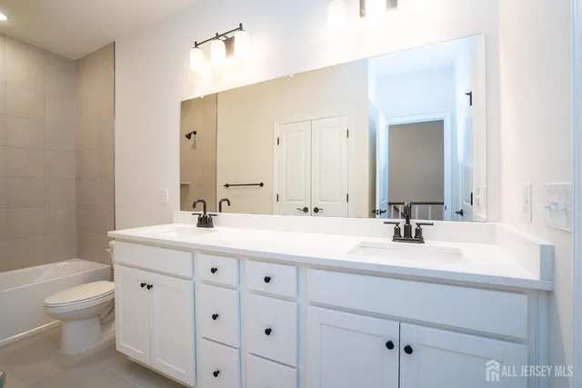 a bathroom with a granite countertop sink a toilet and a mirror