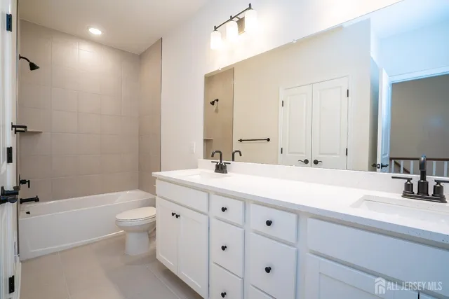 a bathroom with a double vanity sink toilet and shower