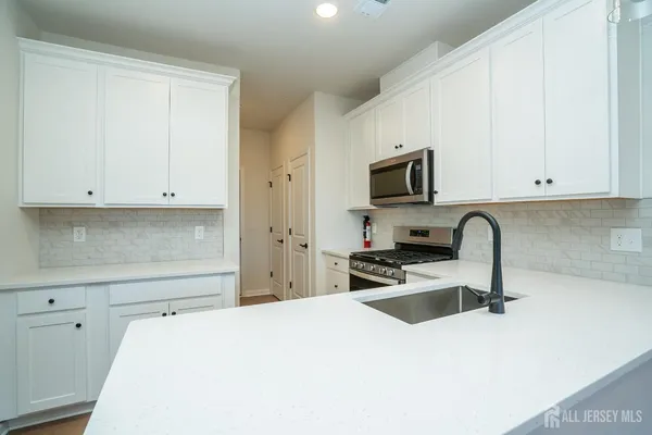 a kitchen with granite countertop white cabinets and sink