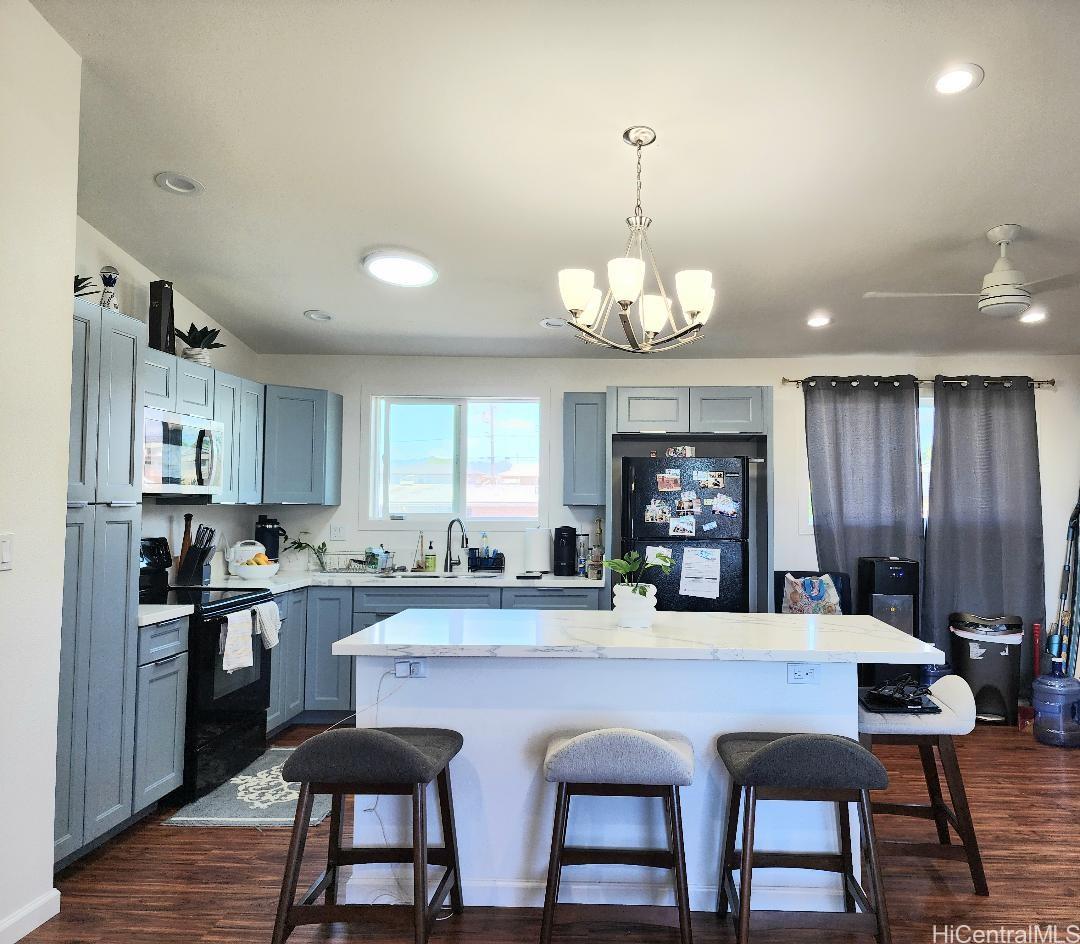 a kitchen with stainless steel appliances granite countertop a stove top oven a sink dishwasher a dining table and chairs with wooden floor