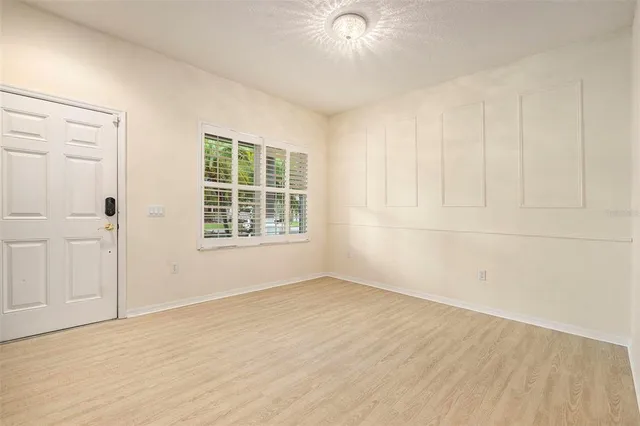an empty room with wooden floor and windows