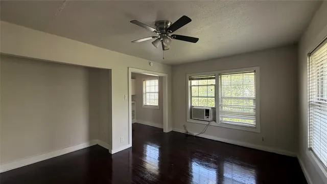 a very nice looking room with wooden floor and ceiling fan