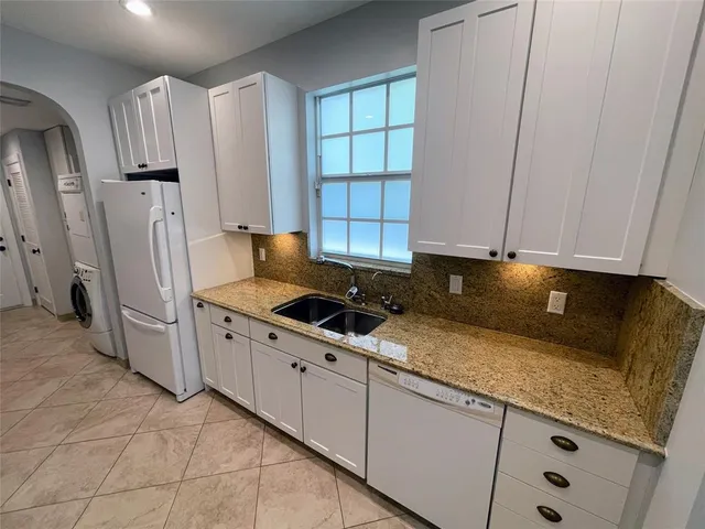 a view of a house with a yard and palm trees