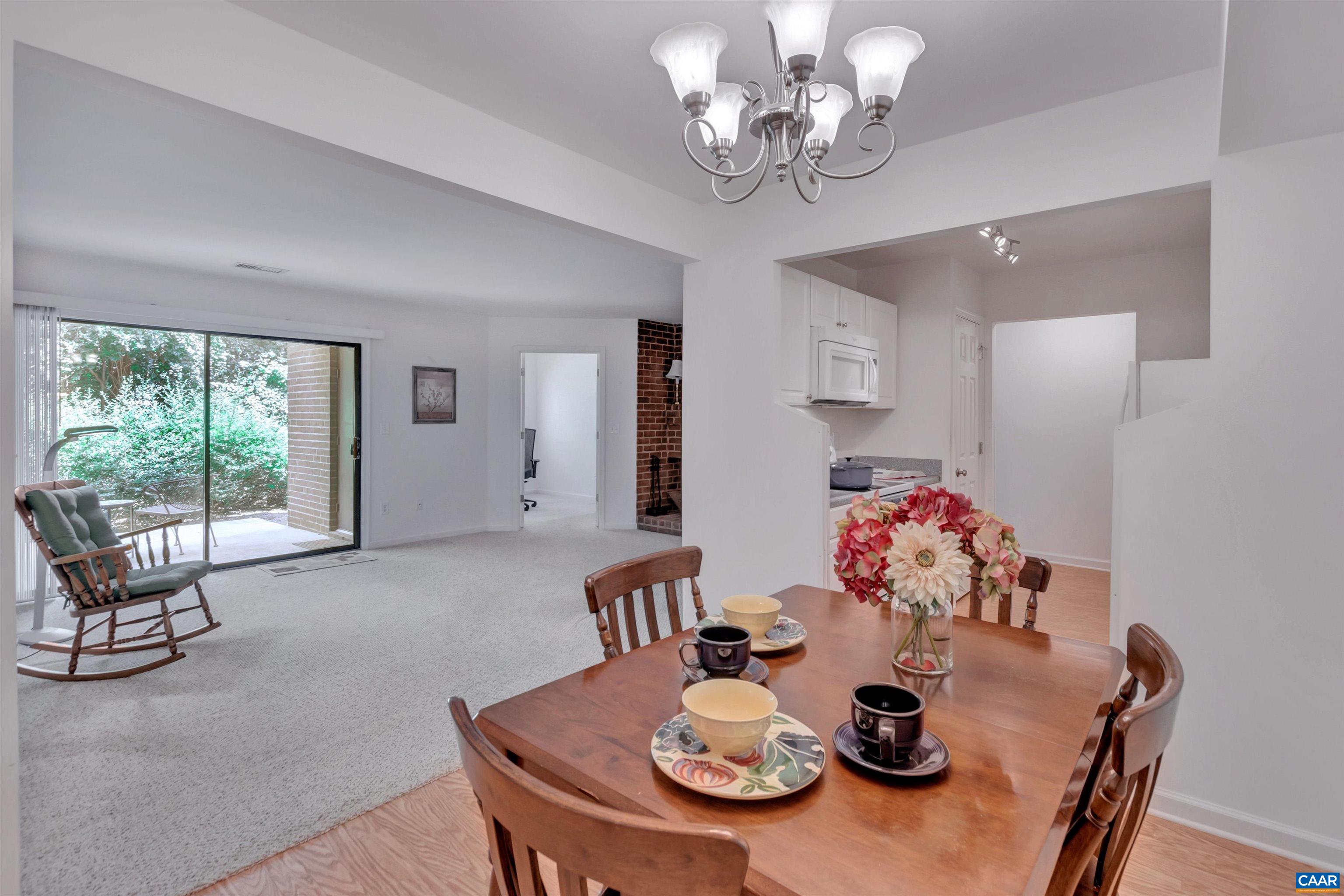 a view of a dining room with furniture a chandelier and wooden floor