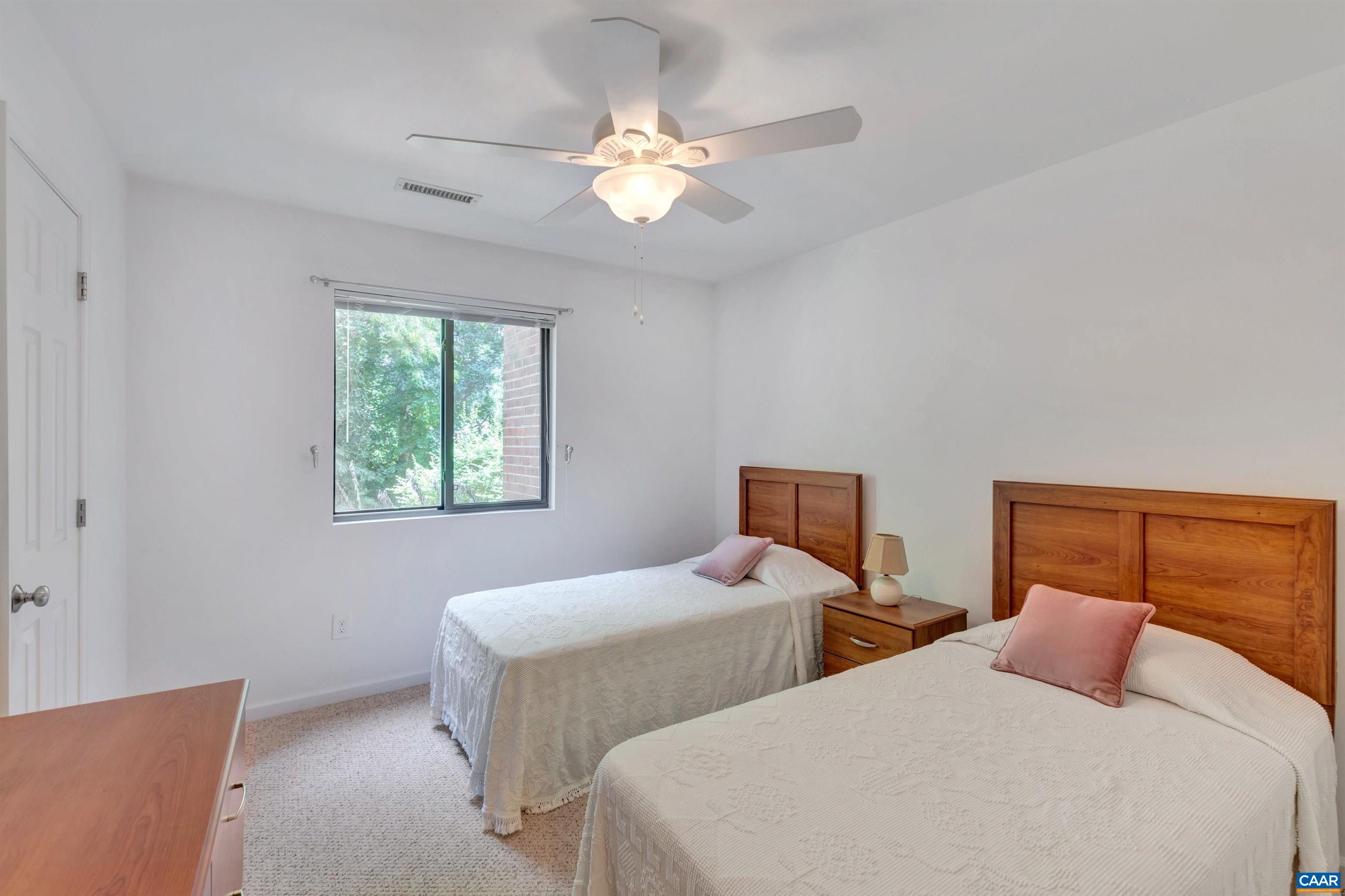 125 Turtle Creek Road, Unit 2 Charlottesville, VA 22901 - Photo 20 of 33 a bedroom with two beds and a chandelier