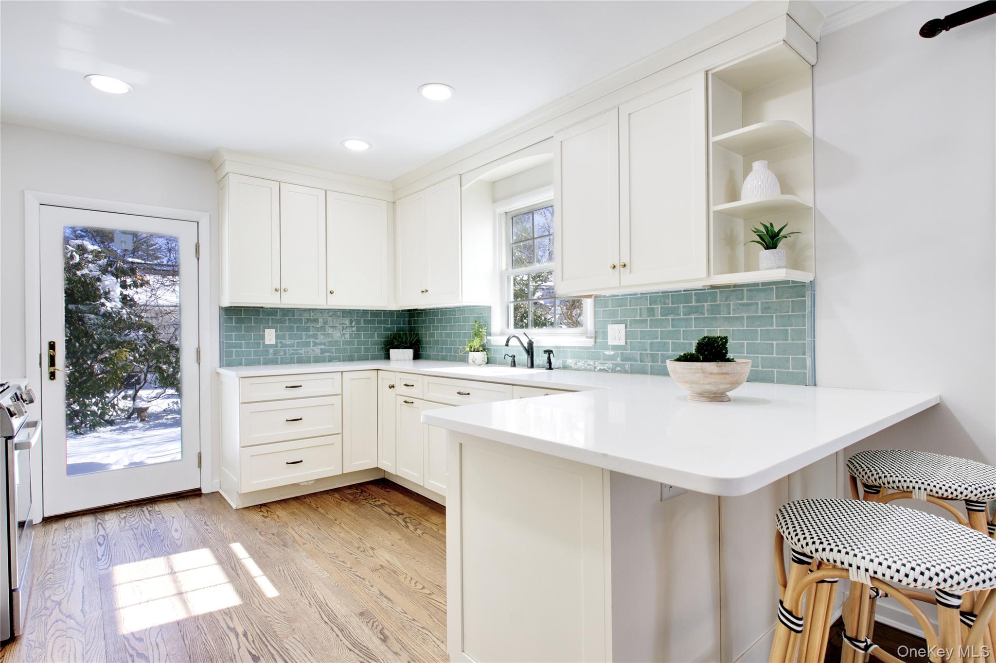 27 Avalon Road Garden City, NY 11530 - Photo 7 of 31 Beautifully Renovated Kitchen (10 years ago) with peninsula for stool seating, glass subway tile backsplash, quartz countertops, custom cabinetry, Bosch appliances
