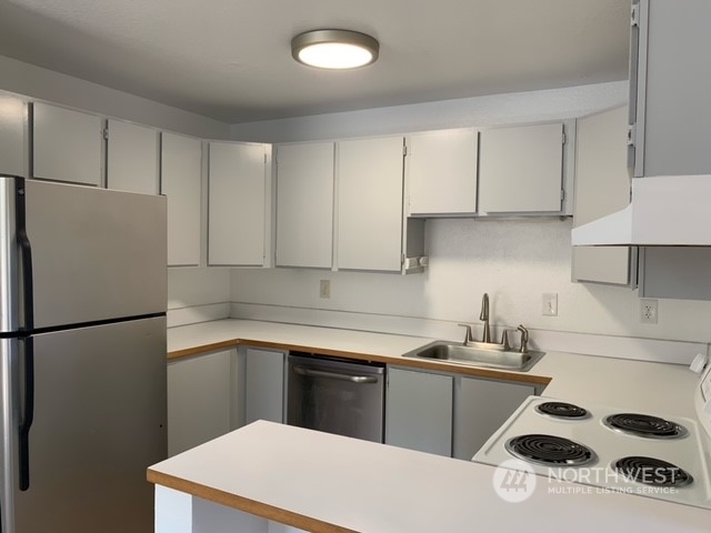 808 Main Street Sultan, WA 98294 - Photo 8 of 13 a kitchen with a refrigerator sink and cabinets