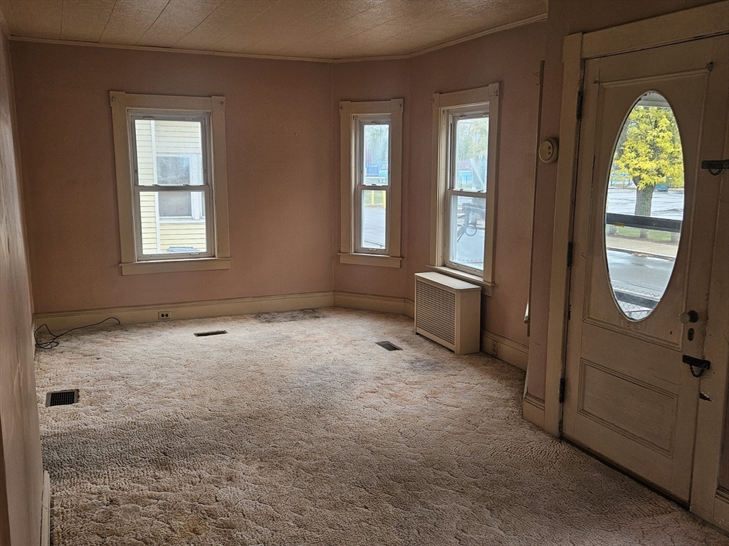 49 Sparks Street Lowell, MA 01854 - Photo 7 of 27 an empty room with windows wooden floor and glass door