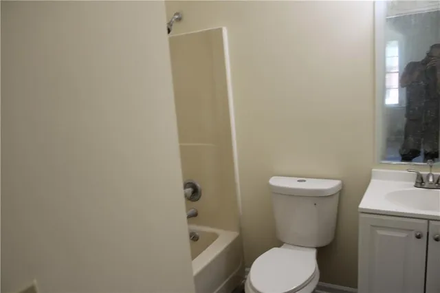 a white toilet sitting next to a bathroom sink