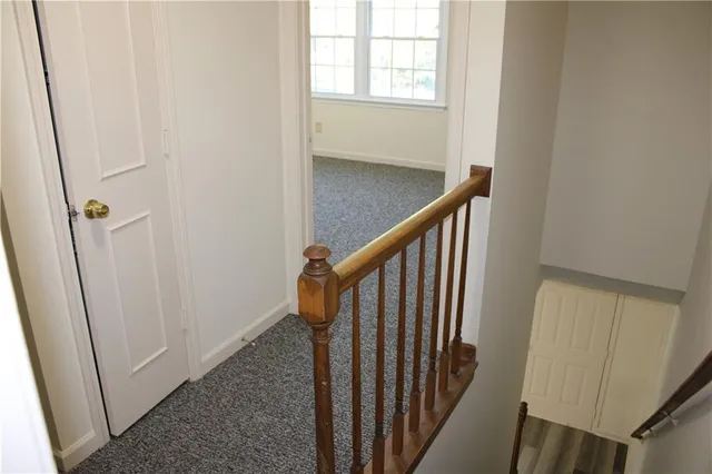 a view of a hallway with wooden floor and entryway