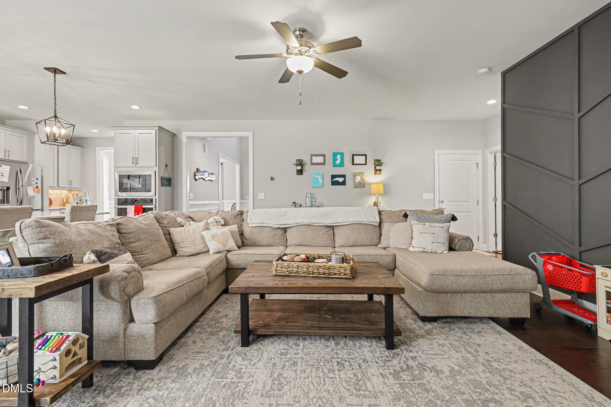274 Colson Ridge Drive Clayton, NC 27520 - Photo 12 of 48 a living room with furniture a rug and a chandelier
