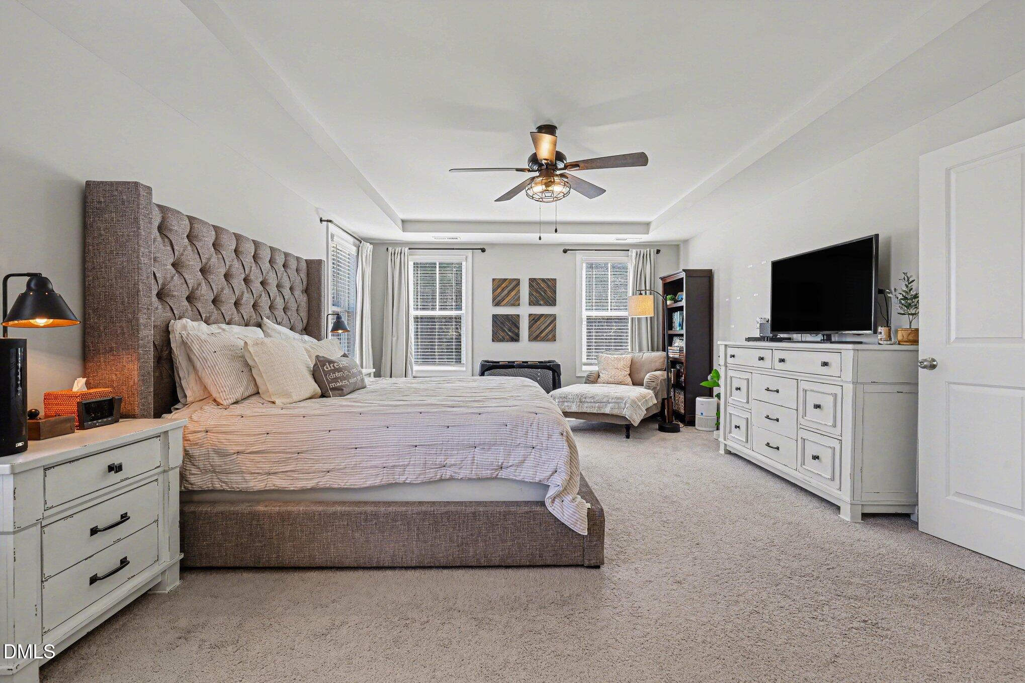 274 Colson Ridge Drive Clayton, NC 27520 - Photo 28 of 48 a spacious bedroom with a bed and flat screen tv